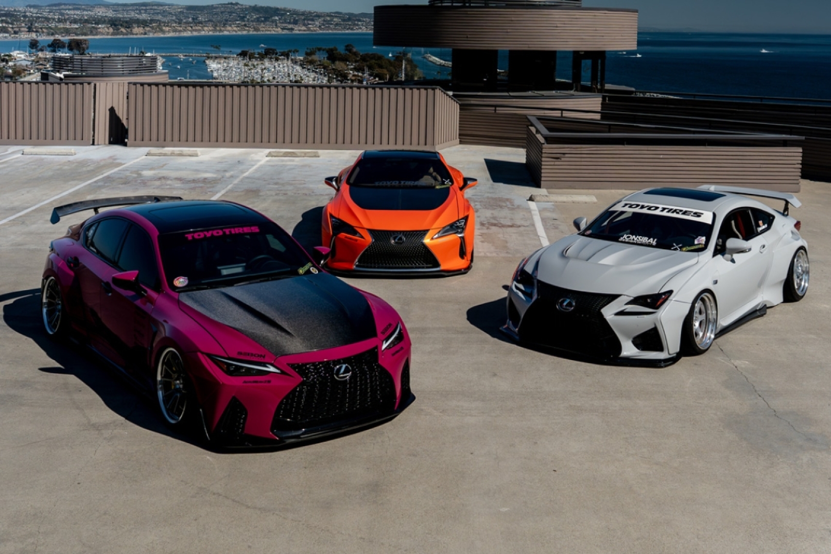The Balthasar family’s three custom widebody Lexus builds parked together on a rooftop overlooking the ocean.